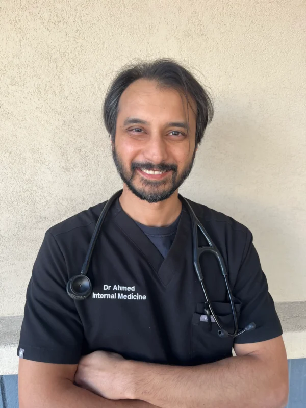 Smiling Doctor in Black Scrubs with Stethoscope Promoting Direct Primary Care